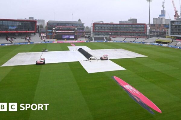 Old Trafford with covers on as rain falls