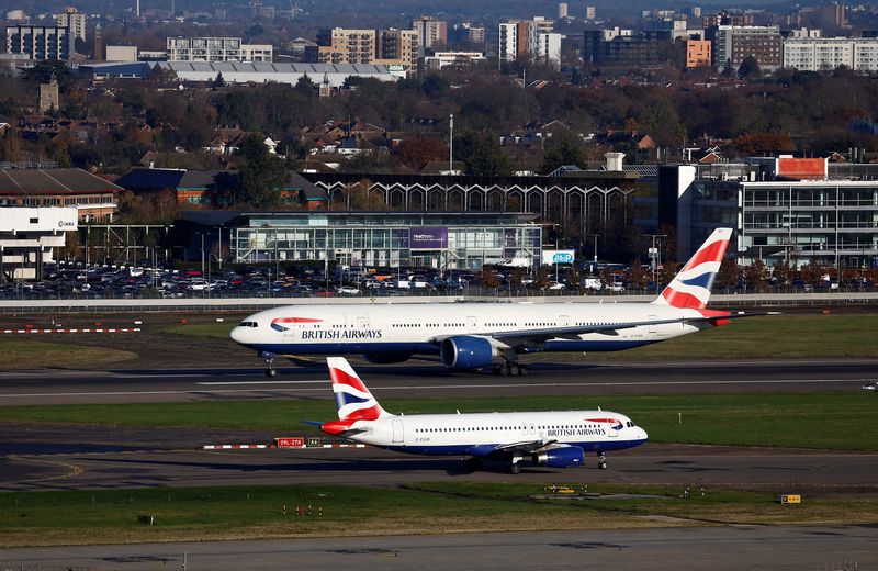 FILE PHOTO: A British Airways Boeing 777 passes a British Airways Airbus as it takes off from Heathrow Airport