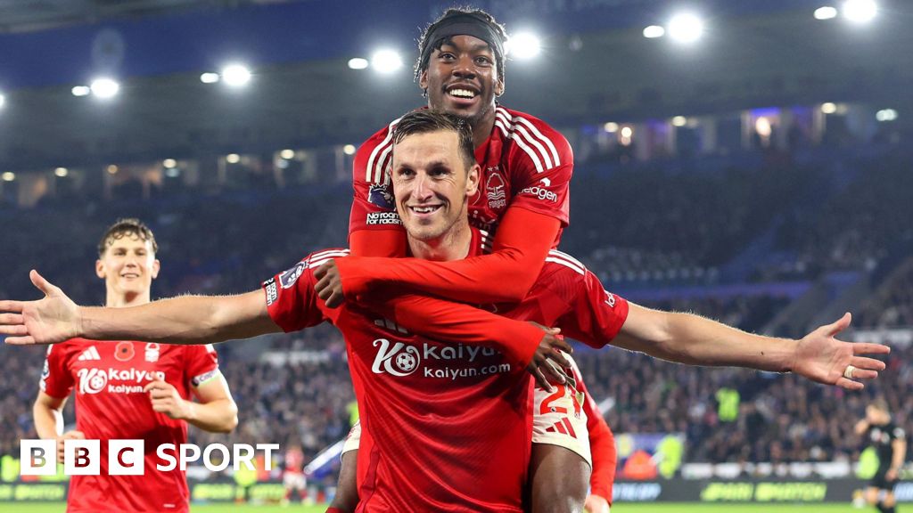 Chris Wood celebrates with his arms outstretched and Anthony Elanga jumping on his shoulders.