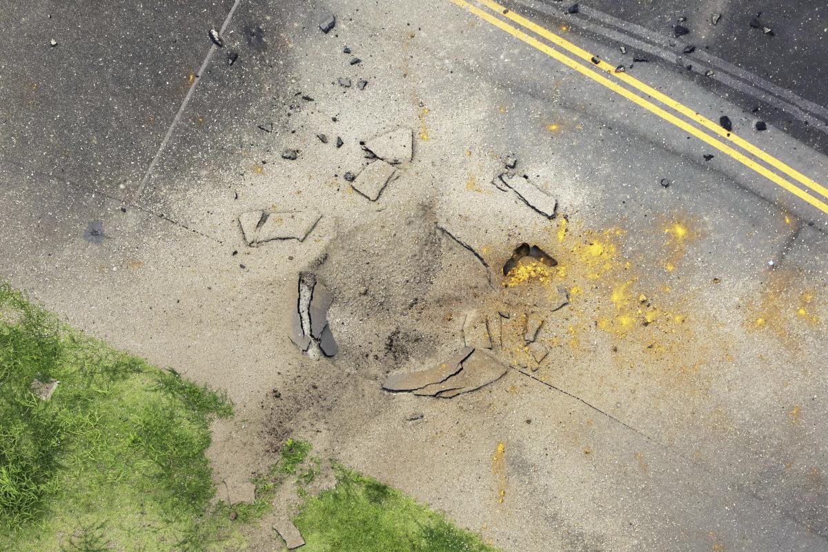A US bomb from World War II explodes at a Japanese airport, causing a large crater in a taxiway