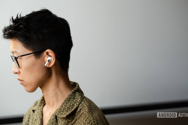 A person wears the Apple AirPods Pro (2nd generation) in profile view.