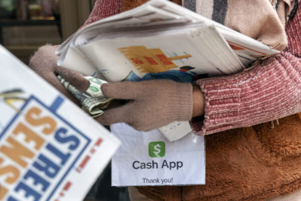 A vendor selling Street Sense, a local paper that covers issues related to the homeless and employs...