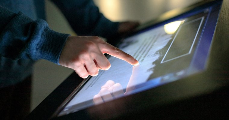 person uses the interactive touchscreen of an electronic multimedia kiosk