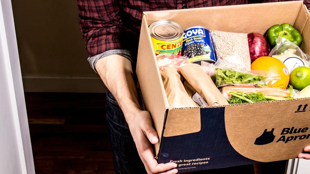 man carrying meal kit box out the door