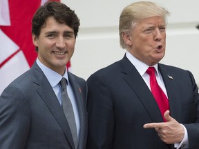 Donald Trump at right points at Justin Trudeau