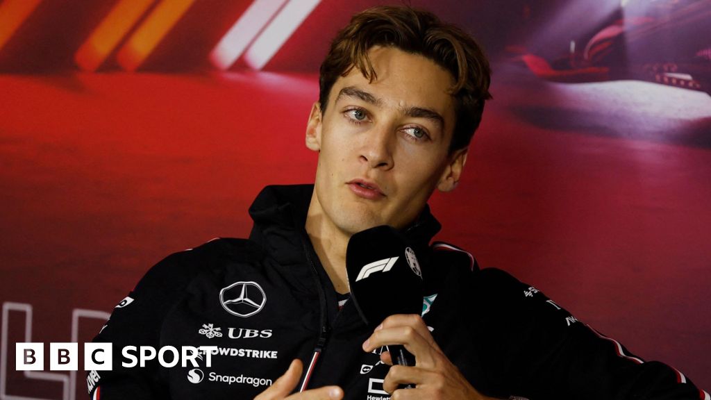 Mercedes driver George Russell speaking into a microphone with the F1 logo during the drivers' press conference for the Las Vegas Grand Prix