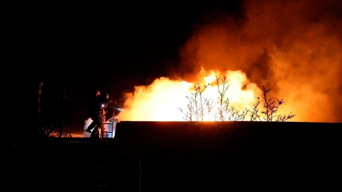 Ukrainian rescue workers put out a fire on a building damaged by a Russian strike on Dnipro, UKraine