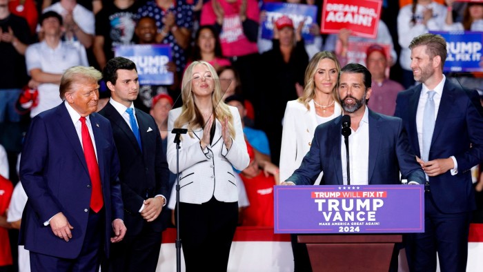 Donald Trump Jr speaking at a campaign rally alongside members of the Trump family
