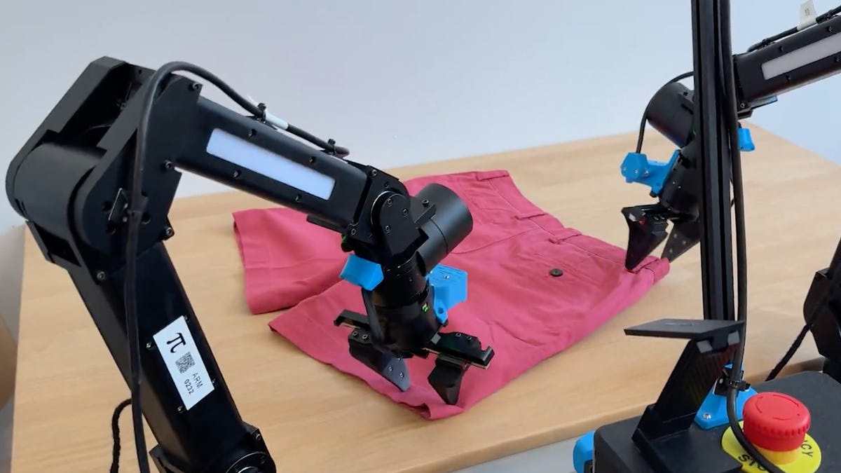 two robotic arms folding a pair of shorts