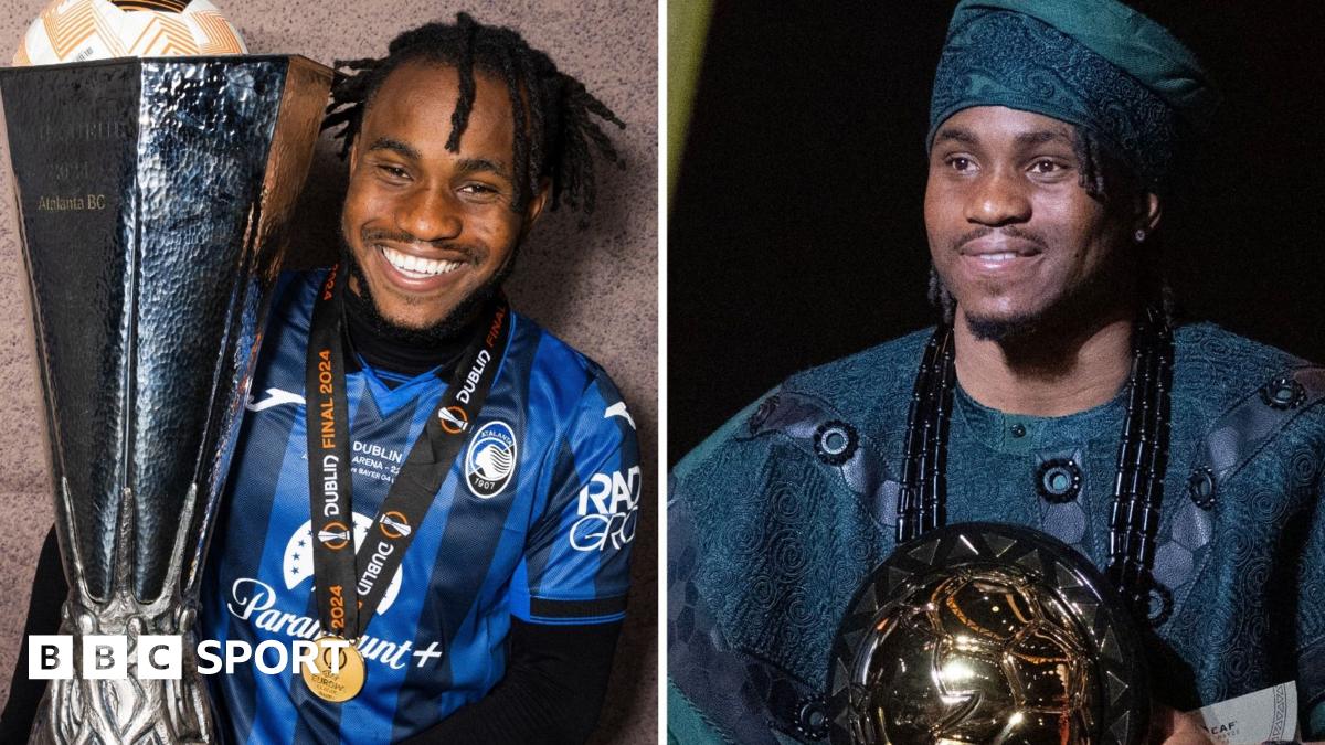 Ademola Lookman, wearing a traditional dark green Nigerian robe and matching hat, stands at a podium to give a speech after being named African Footballer of the Year