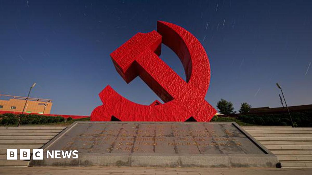 A sculpture of the Chinese Communist Party logo - a hammer and sickle in red.