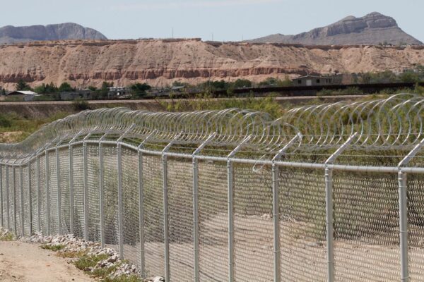 A privately owned fence extends toward the U.S. border, with Mexico in the distance. (AP Photos/Morgan Lee)