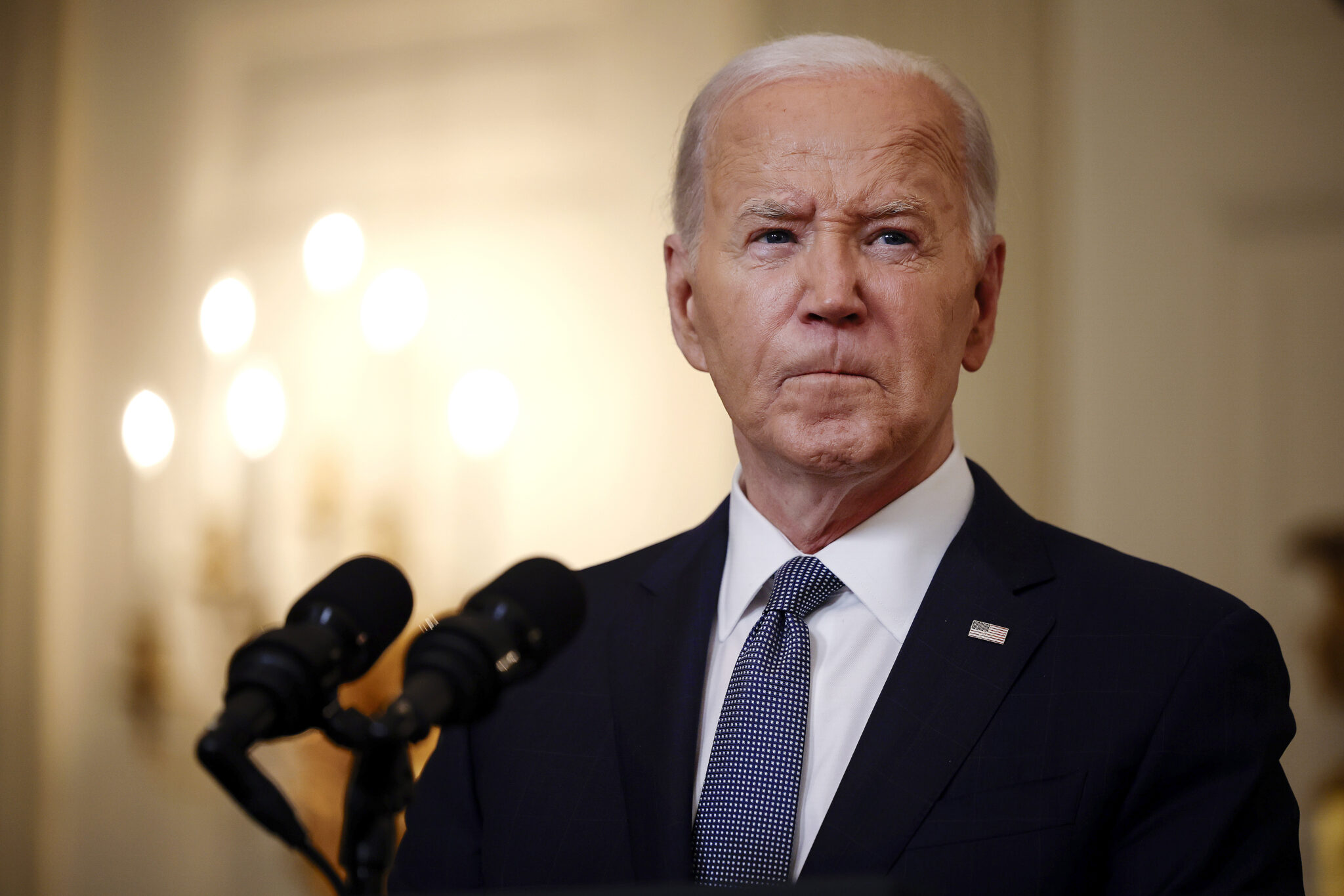 A man in a suit behind microphones