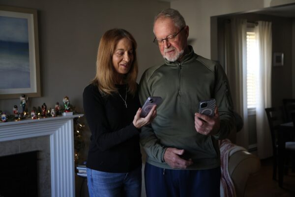 Steven Kahn and Diane Vanasse Kahn in their Peabody home with their phones. The couple got what they considered to be a great offer for new iPhones from T-Mobile at Costco in Everett. But when their statements arrived, the promised credits were nowhere to be found.