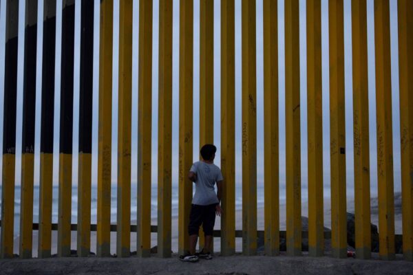 A boy looks through a border wall separating Mexico from the United States, Nov. 26, 2024, in Tijuana, Mexico. (AP Photo/Gregory Bull, File)