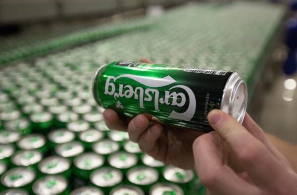 A worker checks cans of Carlsberg beer as they move along the production line at the OAO Baltika brewery, operated by Carlsberg A/S, in Saint Petersburg, Russia