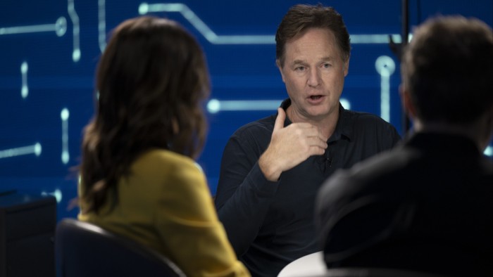 Nick Clegg gestures as he speaks. He can be seen between two people with their backs to the camera