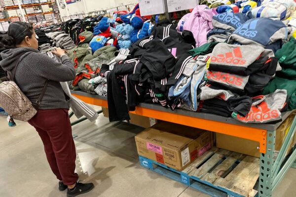 A shopper looks over clothing on display in a Costco warehouse Wednesday, Dec. 4, 2024, in Sheridan, Colo. (AP Photo/David Zalubowski)