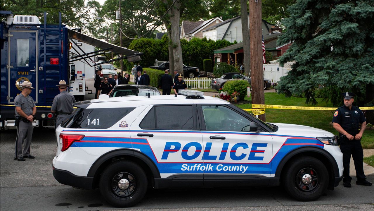 Police officers stand guard near the house where a suspect has been taken into custody on New York's Long Island on July 14, 2023, in Massapequa Park, N.Y. (AP Photo/Eduardo Munoz Alvarez, File)