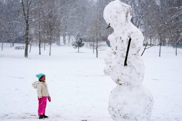 Brooklyn Brye, 4, looks up at giant snowman, in Nashville, Tenn., Friday, Jan. 10, 2025. (AP Photo/George Walker IV)