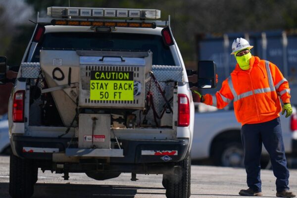 A worker is bundled up in near-freezing temperatures as he loads into a salt spreading truck at the Texas Department of Transportation Dallas Southwest lot as crews prepare the roads ahead of a winter storm expected to hit the North Texas region, Tuesday, Jan. 7, 2025, in Cedar Hill, Texas. (AP Photo/Julio Cortez)