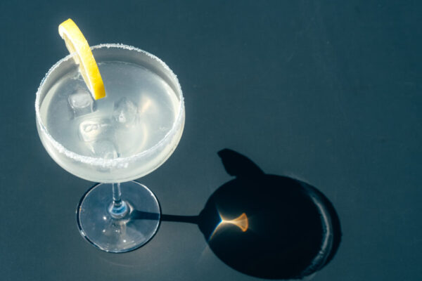 Glass with margarita cocktail on the table in a sunny day.