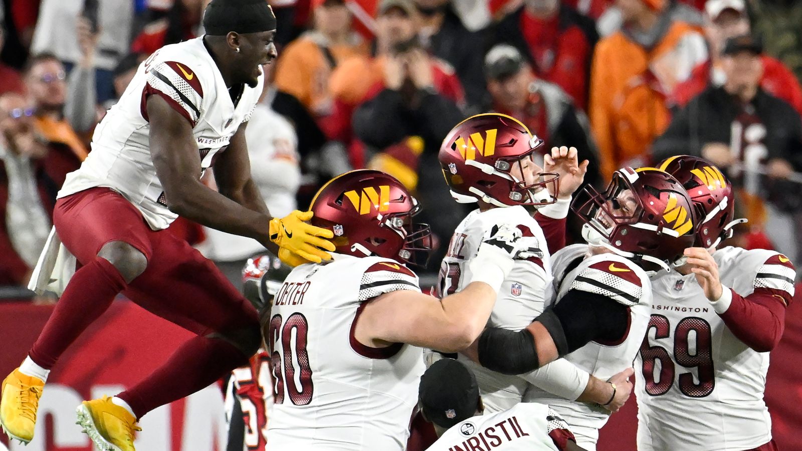Washington Commanders place kicker Zane Gonzalez, middle, is congratulated by teammates after kicking the game winning field goal against the Tampa Bay Buccaneers during the second half of an NFL wild-card playoff football game in Tampa, Fla., Sunday, Jan. 12, 2025. (AP Photo/Jason Behnken)