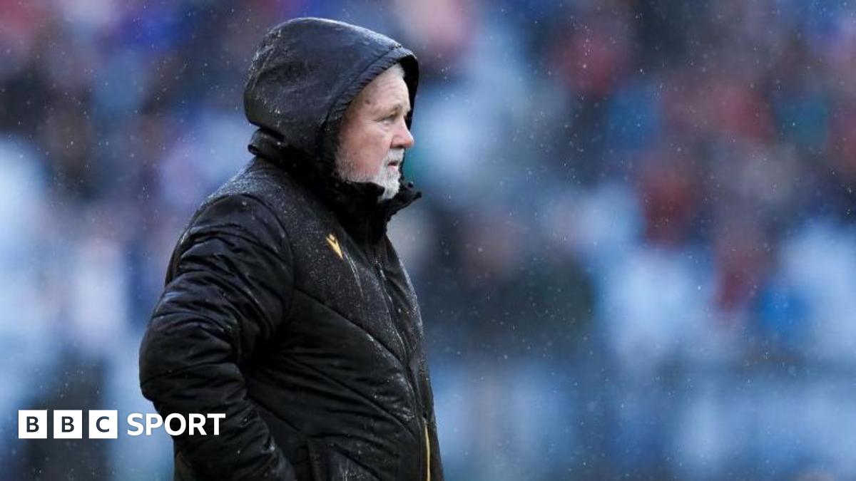 Warren Gatland in black coat in rain