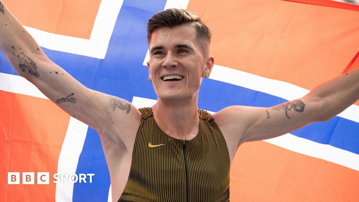 Jakob Ingebrigtsen celebrates by holding aloft the flag of Norway