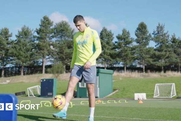 Rodri in training kit, kicking a football