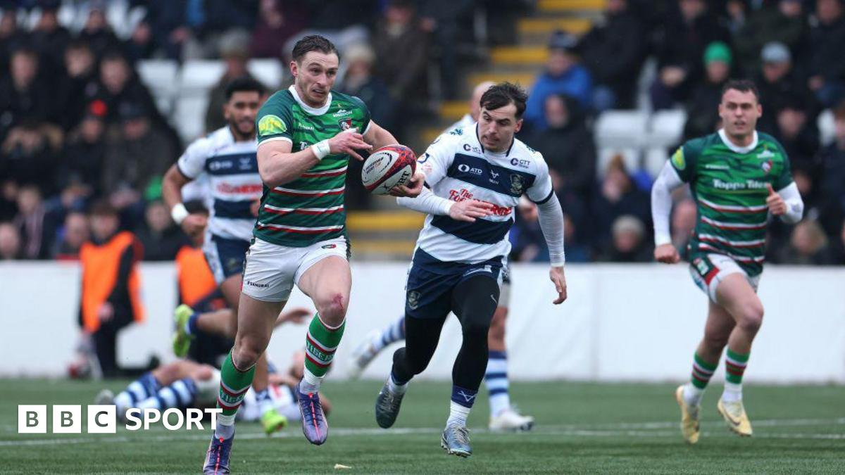 rugby player runs away from defenders with ball in hand