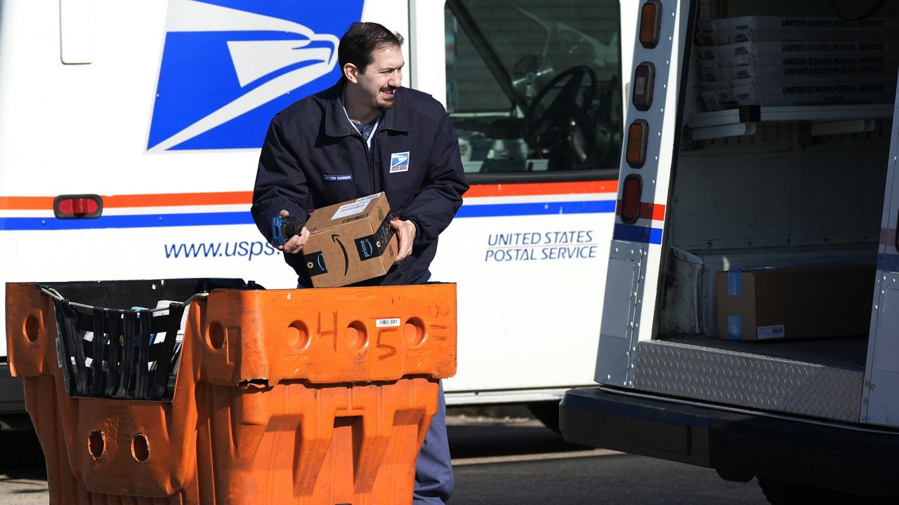 A U.S. Postal Service employee loads parcels outside a post office in Wheeling, Ill., on Jan. 29, 2024. (AP Photo/Nam Y. Huh, File)