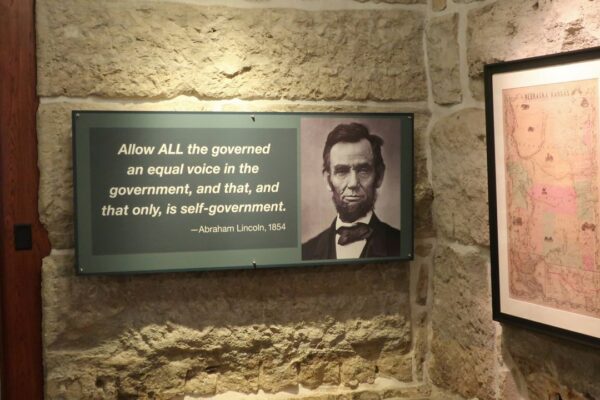 A historical exhibit at the Kansas Statehouse includes a display quoting President Abraham Lincoln next to a map showing the original extent of the Kansas-Nebraska territories before Kansas became a state and Lincoln took office in 1861, Thursday, Feb. 13, 2025, in Topeka, Kansas. (AP Photo/John Hanna)