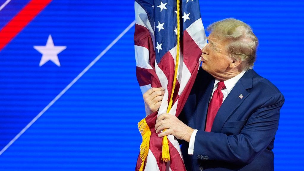 File photo of then presidential candidate Donald Trump hugs and kisses the American flag as he speaks at CPAC on Feb. 24, 2024. (AP Photo/Alex Brandon)