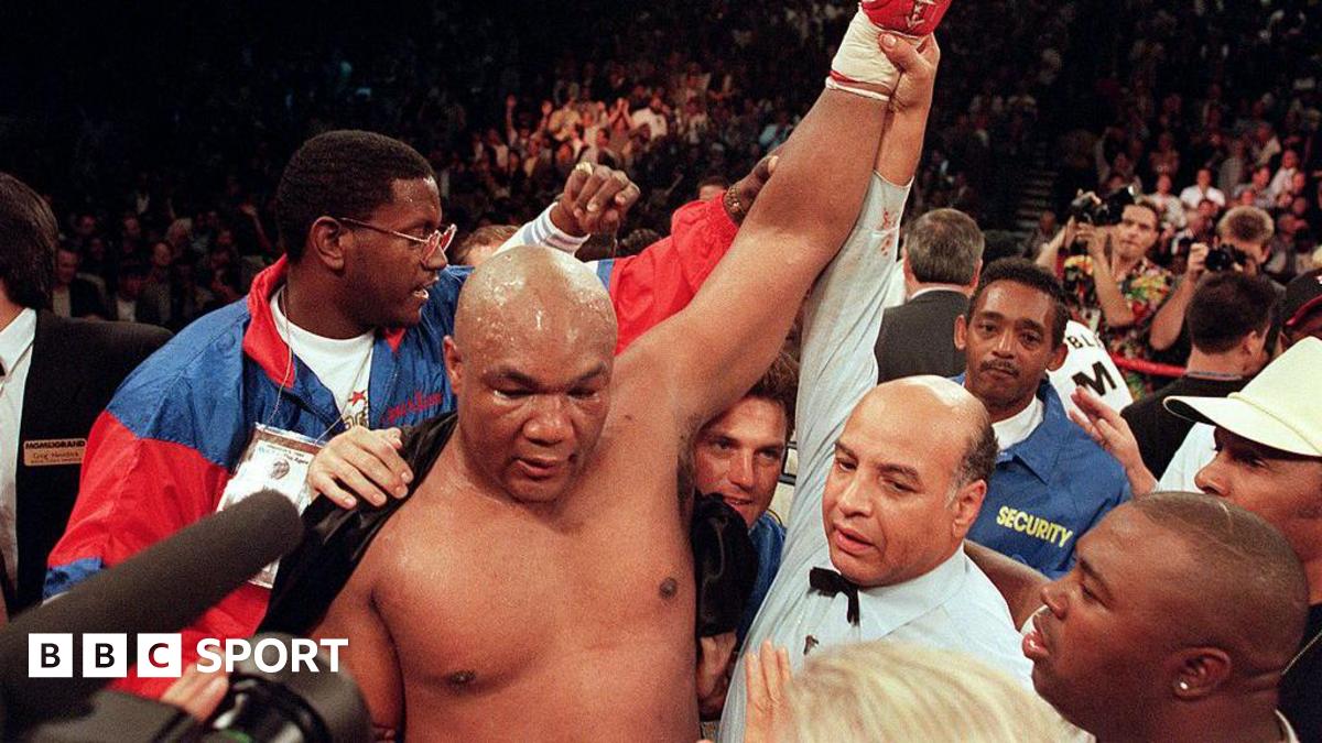 George Foreman has his hand raised by the referee