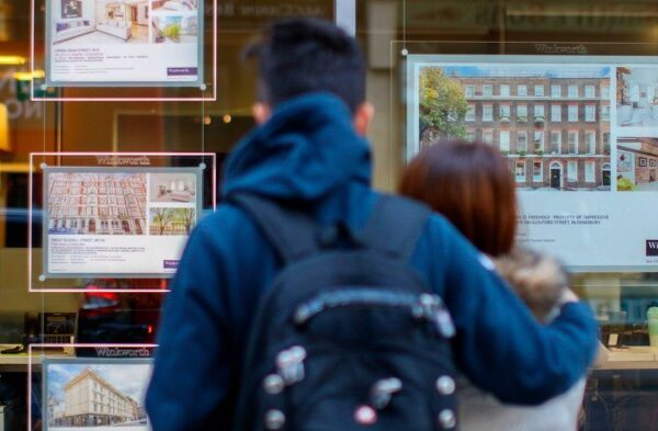 People look at an estate agent office’s window in central London