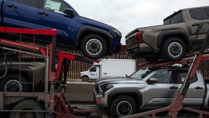 A cargo truck loaded with new pickups heads to US at the Otay Commercial crossing in Tijuana