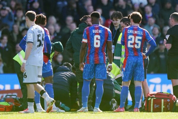 Players from both sides look on as Crystal Palace's Jean-Philippe Mateta receives treatment following a challenge from Millwall goalkeeper Liam Roberts