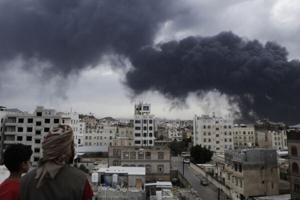 Yemenis watch as smoke billows following Israeli airstrikes targeting a power plant and Sanaa Airport, in Sanaa, Yemen, Tuesday, May 6, 2025. (AP Photo/Osamah Abdulrahman)
