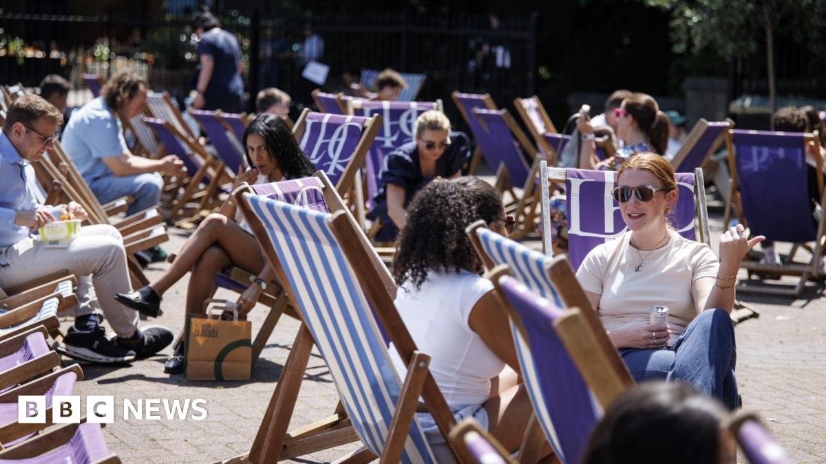 People sit on deckchairs during sunshine in London