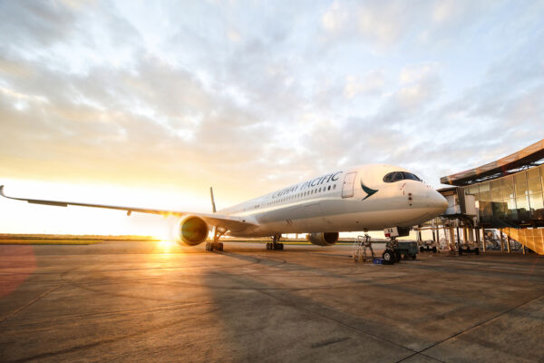 A Cathay Pacific A350 on the tarmac at dawn.