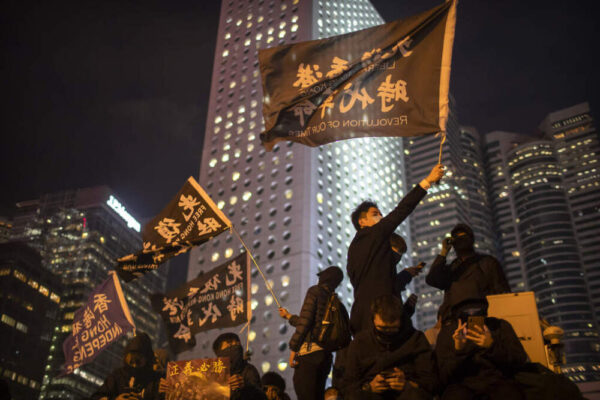 A protestor holds a flag that reads: "Liberate Hong Kong, Revolution of Our Times" at a rally in Hong Kong, on Dec. 12, 2019. (AP Photo/Mark Schiefelbein, File)