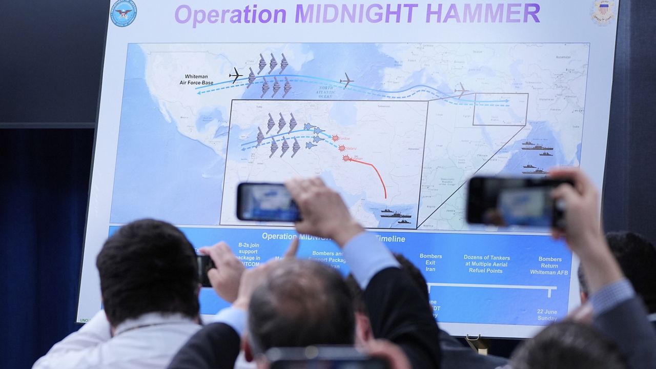 Reporters take photos of a displayed graphic as Defense Secretary Pete Hegseth and Joint Chiefs Chairman Gen. Dan Caine speak during a news conference at the Pentagon in Washington, Sunday, June 22, 2025, after the U.S. military struck three sites in Iran, directly joining Israel's effort to destroy the country's nuclear program. (AP Photo/Alex Brandon)