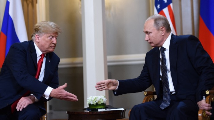 US President Donald Trump and Russian President Vladimir Putin reach to shake hands before a meeting in 2018