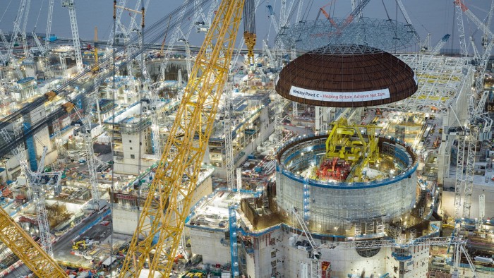 Engineering teams use the massive crane to lift a 245-tonne steel dome onto the first reactor building at Hinkley Point C nuclear power station near Bridgwater, England. .