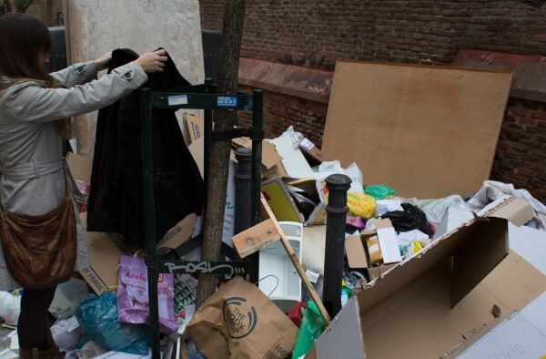 A girl looks at a piece of clothing dumped on a pile of rubbish which blocks a sidewalk during the fourth day of a garbage collectors strike, in Madrid, Spain