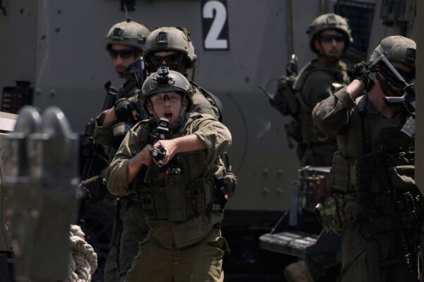 An Israeli soldier points his weapon during a military raid in the West Bank city of Nablus, Tuesday, June 10, 2025. (AP Photo/Majdi Mohammed)