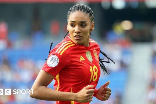 Salma Paralluelo takes a photo of herself kissing her 2023 World Cup winner's medal while lying on the ground surrounded by gold confetti