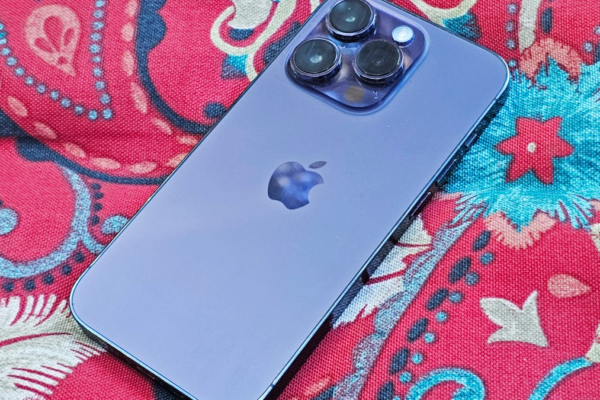 Purple iPhone 14 Pro face down on a red patterned pillow