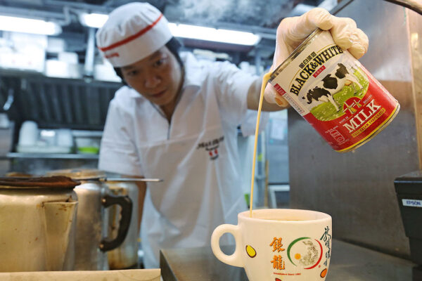 Staff making Hong Kong-style milk tea at Ngan Lung Catering Group Cha Chaan Teng in Mei Foo, Hong Kong